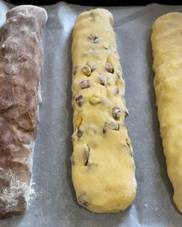 Tre pezzi di pasta sono appoggiati su un pezzo di carta oleata