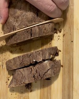 Una persona sta tagliando una pagnotta di pane su un tagliere