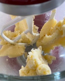 Un mixer sta mescolando il burro in una ciotola di vetro