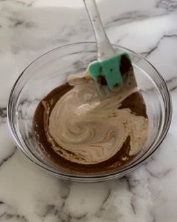 Una ciotola di salsa al cioccolato con una spatola dentro.