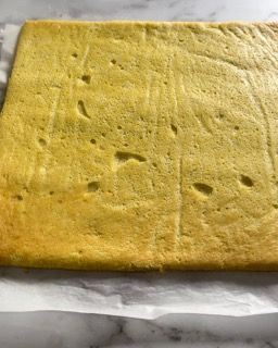 Una fetta di torta è appoggiata su un foglio di carta oleata su un tavolo.