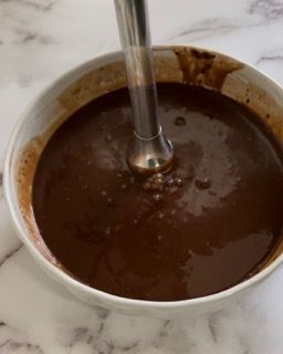 Una ciotola di salsa al cioccolato con un frullatore dentro.