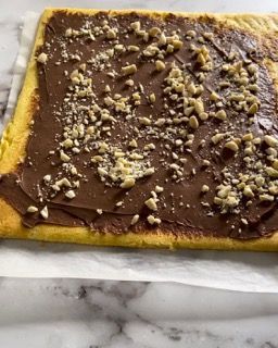 Un pezzo di torta con glassa al cioccolato e noci sopra