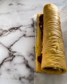 Un panino è appoggiato su una superficie di marmo.