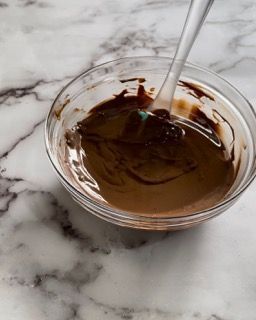 Una ciotola di salsa al cioccolato con un cucchiaio dentro
