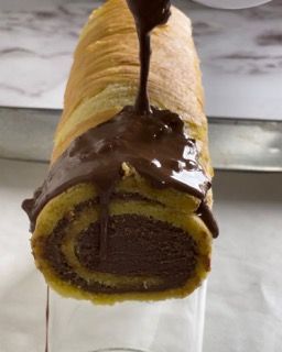 Un rotolo di torta al cioccolato viene versato in un bicchiere.