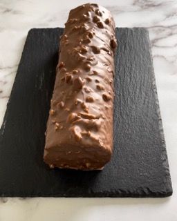 Una tavoletta di cioccolato è appoggiata su un tagliere nero