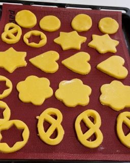 Un mucchio di biscotti di forme diverse su un tappetino rosso