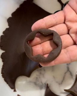 Una persona tiene in mano un pezzo di impasto al cioccolato.