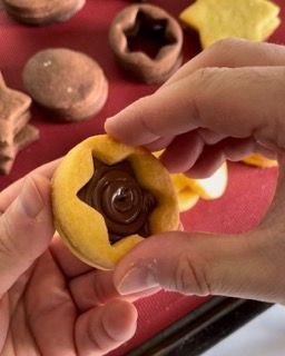 Una persona tiene in mano un biscotto con una stella sopra