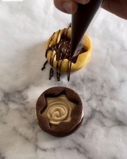 Una persona sta decorando un biscotto con glassa al cioccolato