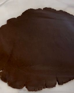 Un pezzo di pasta al cioccolato è appoggiato su un piatto bianco.