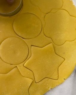 Primo piano di un pezzo di pasta con cerchi e stelle ritagliati.