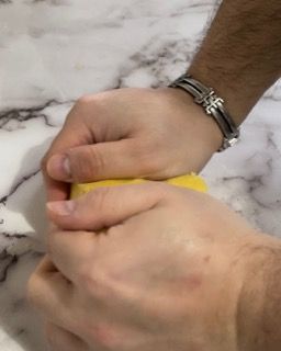 Una persona che indossa un braccialetto sta sbucciando un limone.