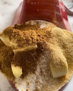 Una tazza graduata piena di fette di banana e cannella