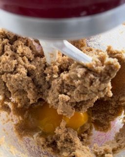 Un mixer sta mescolando un impasto per biscotti con un uovo dentro.