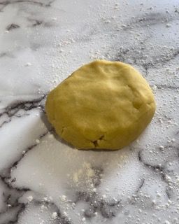 Una palla di pasta è appoggiata su un bancone di marmo.