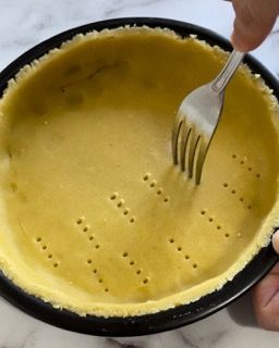 Una persona tiene una forchetta in una crosta di torta