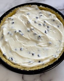 Una torta con mirtilli e panna montata sopra