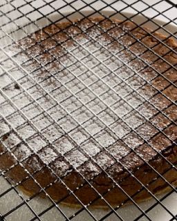 Lo zucchero a velo viene spolverato su un brownie su una griglia di raffreddamento