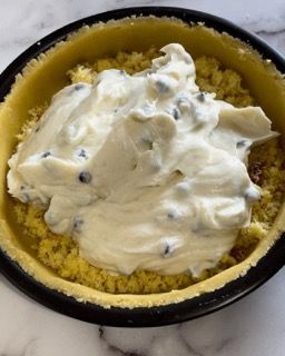 Una ciotola di cibo con panna montata sopra