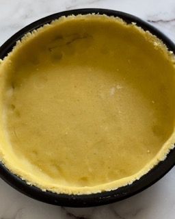 Una pasta per torta è appoggiata su una teglia.