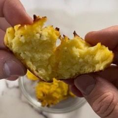 Una persona tiene in mano un pezzo di cibo e ne sta dando un morso.