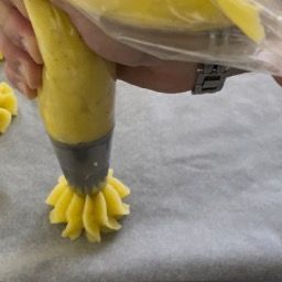 Una persona sta versando la glassa gialla in una sac à poche