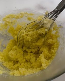 Una frusta è in una ciotola di purè di patate.