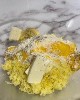 Primo piano di una ciotola di purè di patate con burro e altri ingredienti.