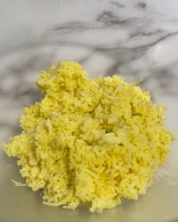 Primo piano di una pila di riso giallo su un tavolo.