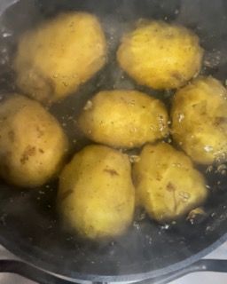 Le patate stanno cuocendo in una padella sul fornello