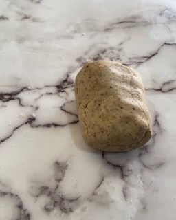Un pezzo di pasta è appoggiato su una superficie di marmo.