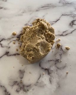 Un pezzo di impasto per biscotti è appoggiato su una superficie di marmo.