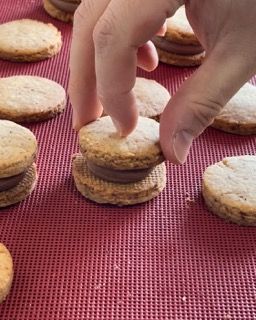 Una persona sta mettendo un biscotto sopra un altro biscotto