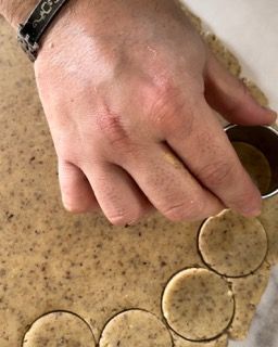 Un primo piano di una persona che taglia dei cerchi dall'impasto