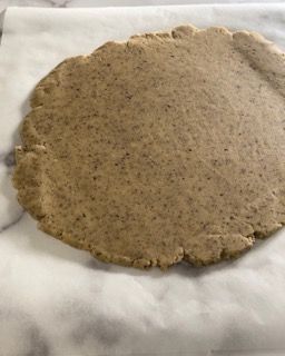 Un pezzo di pasta è appoggiato su un foglio di carta oleata.