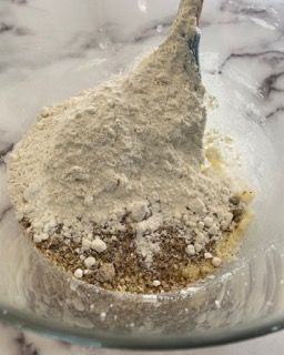 Una ciotola con farina e burro e una spatola dentro.