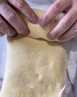 Una persona tiene in mano un pezzo di pasta.