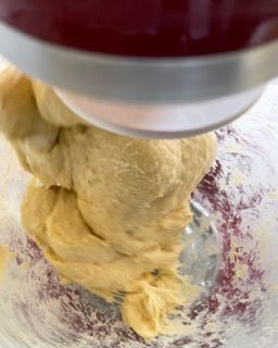 Una persona sta mescolando l'impasto in una ciotola con una planetaria.