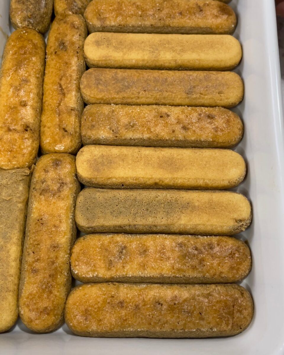 Savoiardi inzuppati velocemente nel caffè espresso per la base del tiramisù.