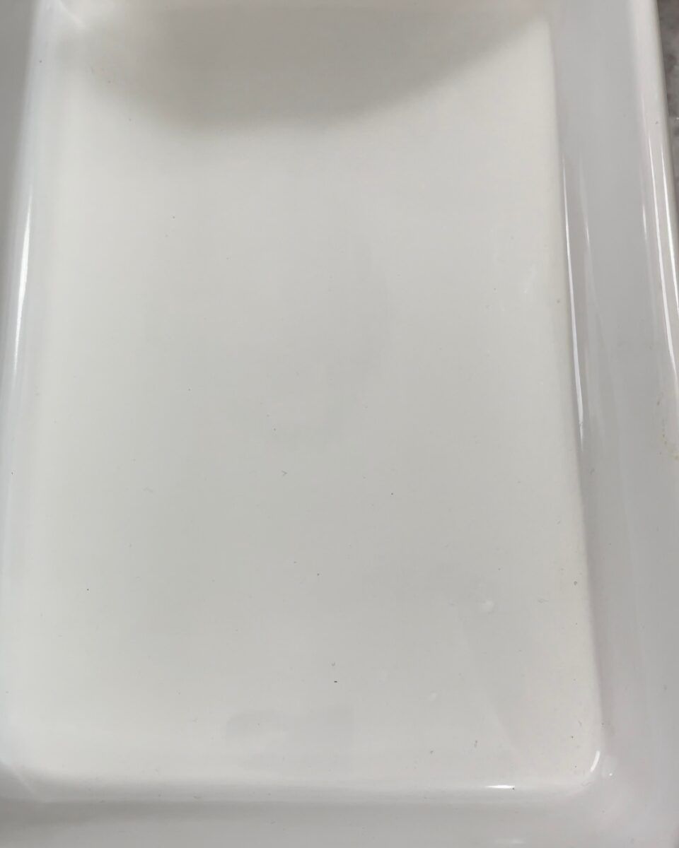 Un piatto rettangolare bianco è appoggiato su un tavolo.