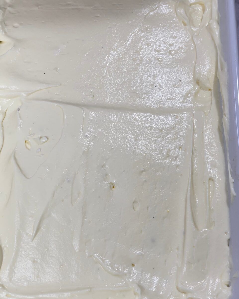 ssemblaggio del tiramisù classico con il primo strato di crema al mascarpone spalmata sui savoiardi.