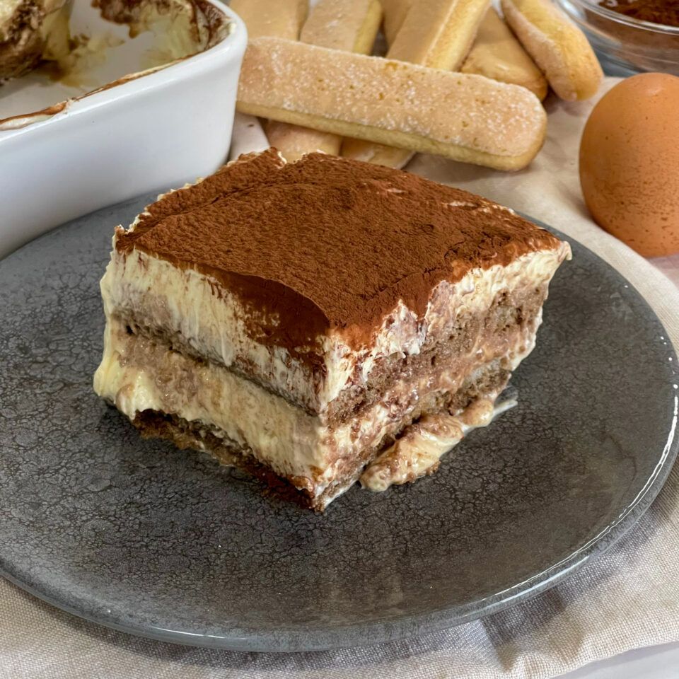 Fetta di tiramisù servita su un piatto, che mostra perfettamente gli strati di savoiardi e crema al mascarpone