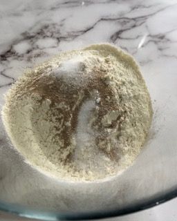 Primo piano di una ciotola di farina su un tavolo.