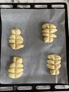 Quattro pezzi di pasta sono appoggiati su una teglia da forno