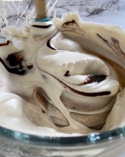 Una ciotola di vetro piena di panna montata e cioccolato