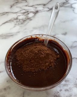 Una ciotola di salsa al cioccolato con un cucchiaio dentro