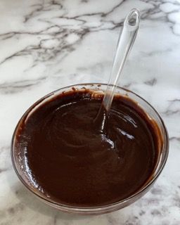Una ciotola di salsa al cioccolato con un cucchiaio dentro