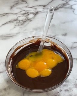 Una ciotola di cioccolato e uova con un cucchiaio dentro